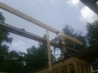 Carpenter setting a ridge beam over a new addition frame — Ice Dam Removal by Roofing Brothers in Lock Haven