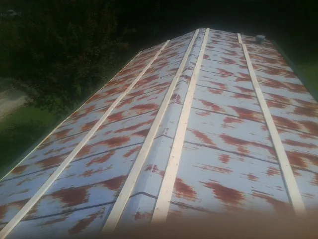 Rusted metal roof panels with new wood purlins before replacement — Storm Damage Roof Repair in Lock Haven by Roofing Brothers