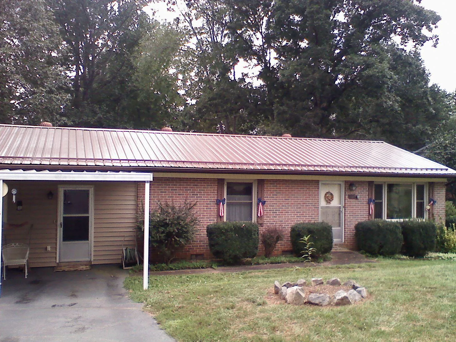 Bronze metal roof and carport on a brick ranch home — Roof Repair work by our crew in Lock Haven