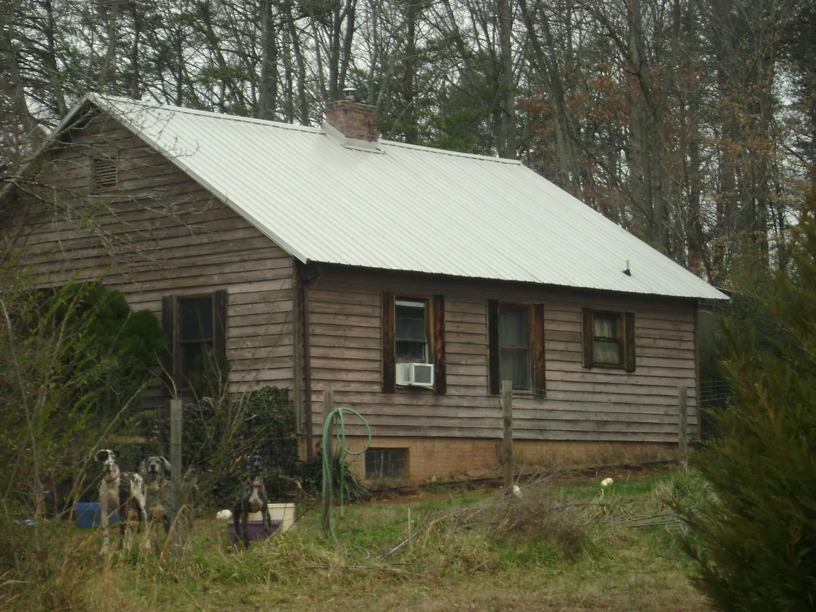 White metal roof on an old wood sided farmhouse, from a Metal Roof Installation job in Lock Haven